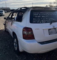 a burned out toyota highlander parked in a parking lot